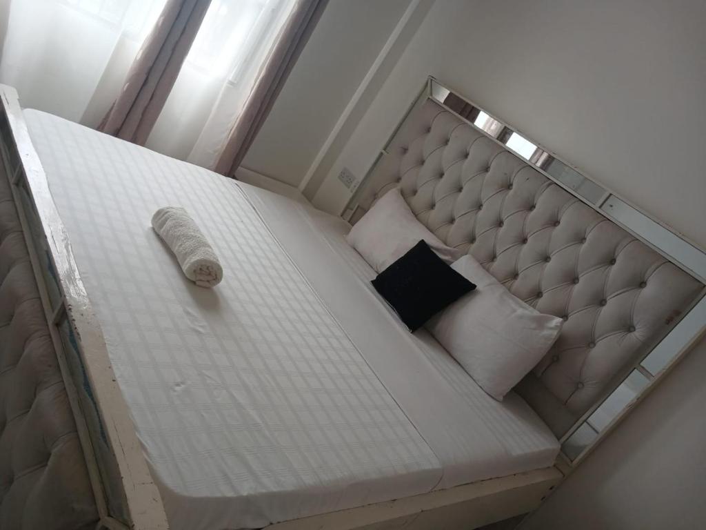 a white bed with a headboard and pillows at Buxton Point Classy 3BR in Mombasa