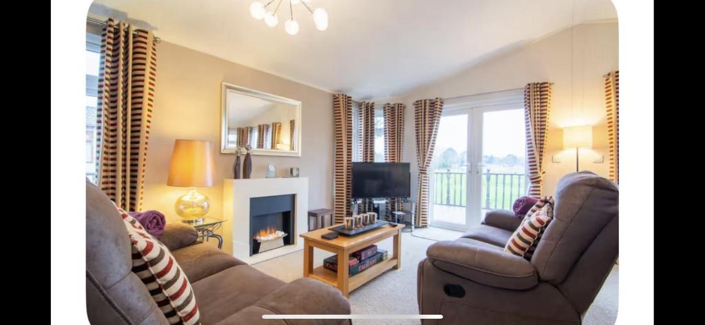 a living room with two couches and a television at par 3 in Wisbech