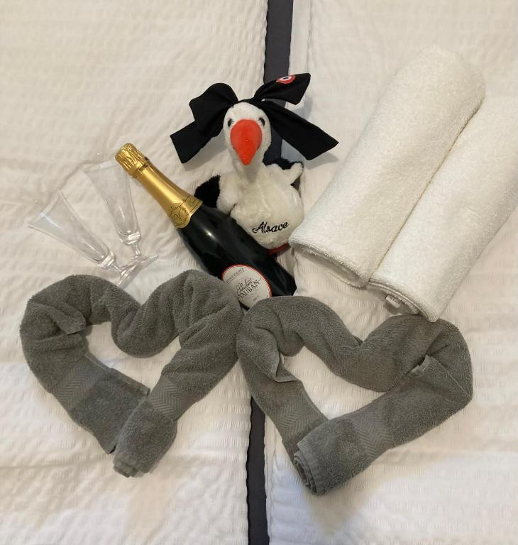 a bottle of champagne and two hearts on a bed at Le Charme de Colmar B&B in Colmar