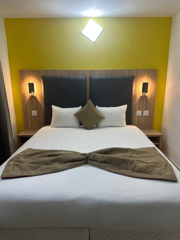 a bedroom with a bed with a bow tie on it at NOROTEL Eco in Brumath
