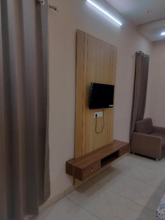 a room with a tv on a wall with a couch at Kanti empire in Dhaulpur