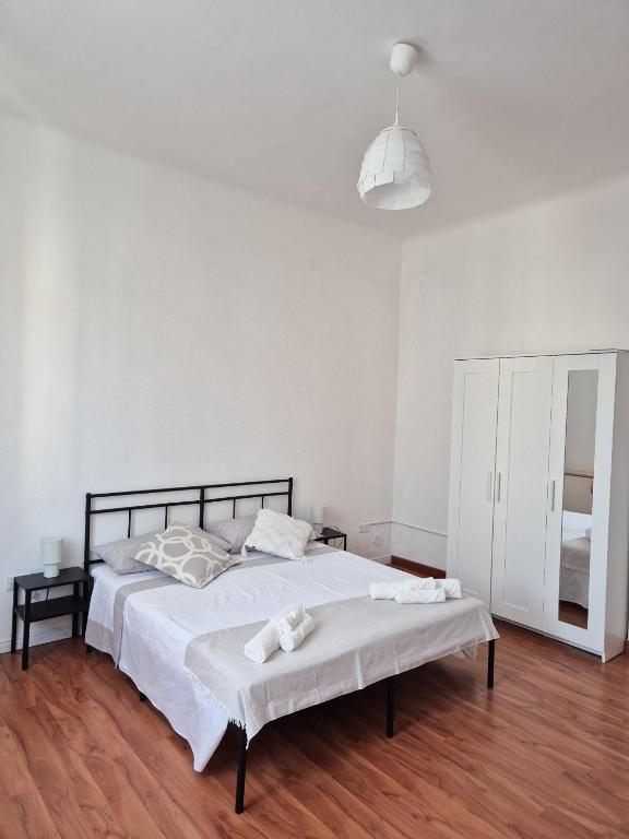 a white bedroom with a bed and a mirror at Punto Zero Ca' Trillina in La Spezia