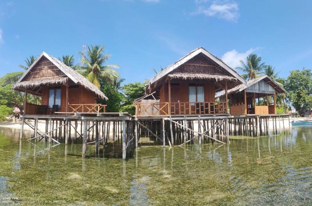 a couple of houses on a pier in the water at Nadi awin kamam in Fambemuk