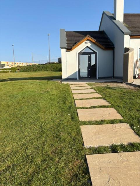 a stone path leading to a house with a door at Dingle Lispole Garden Suite 6 in Lispole