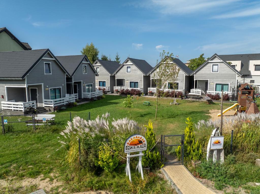 a row of houses with a sign in a yard at Domki Dzika Plaża in Dąbki