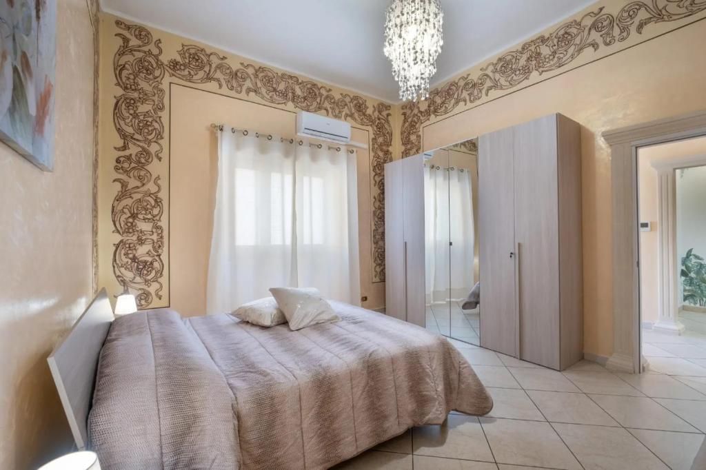 a bedroom with a bed and a chandelier at Relax House in Squinzano