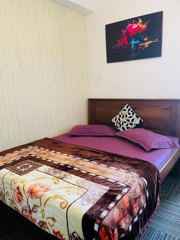 a bedroom with a bed with a colorful comforter at Ivory guest house in Pattipola