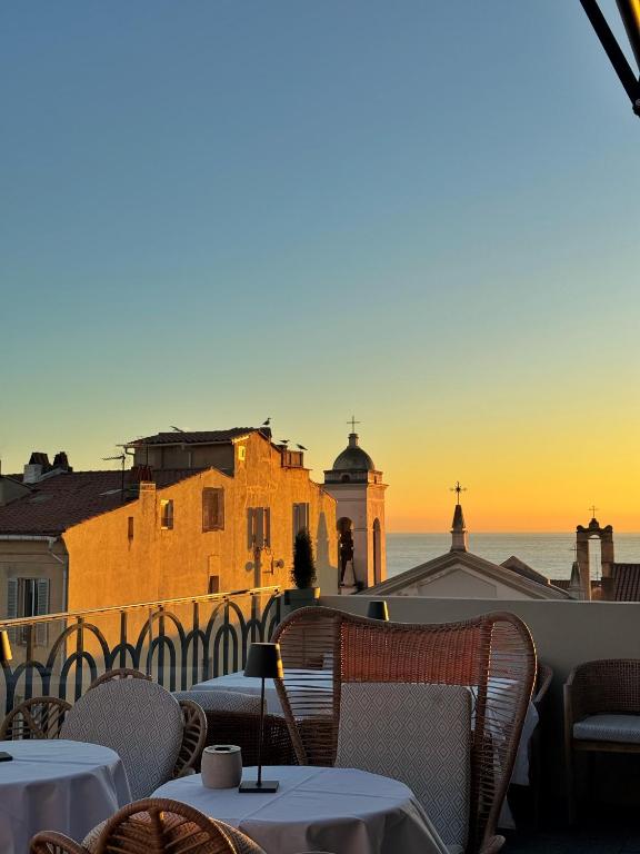 a view of the ocean from a restaurant with tables and chairs at Hotel San Carlu Citadelle Ajaccio in Ajaccio