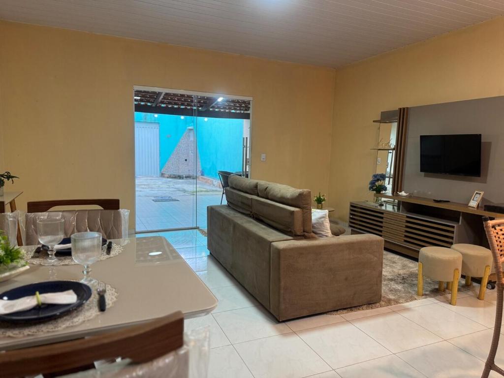 a living room with a couch and a tv at Casa Mobiliada AR02 com 3 camas e 2 quartos in Juazeiro do Norte
