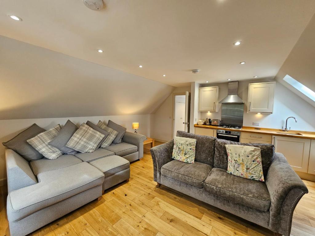 a living room with a couch and a kitchen at The Wee Corsee Cosy Coastal Cottage in the Heart of Nairn in Nairn