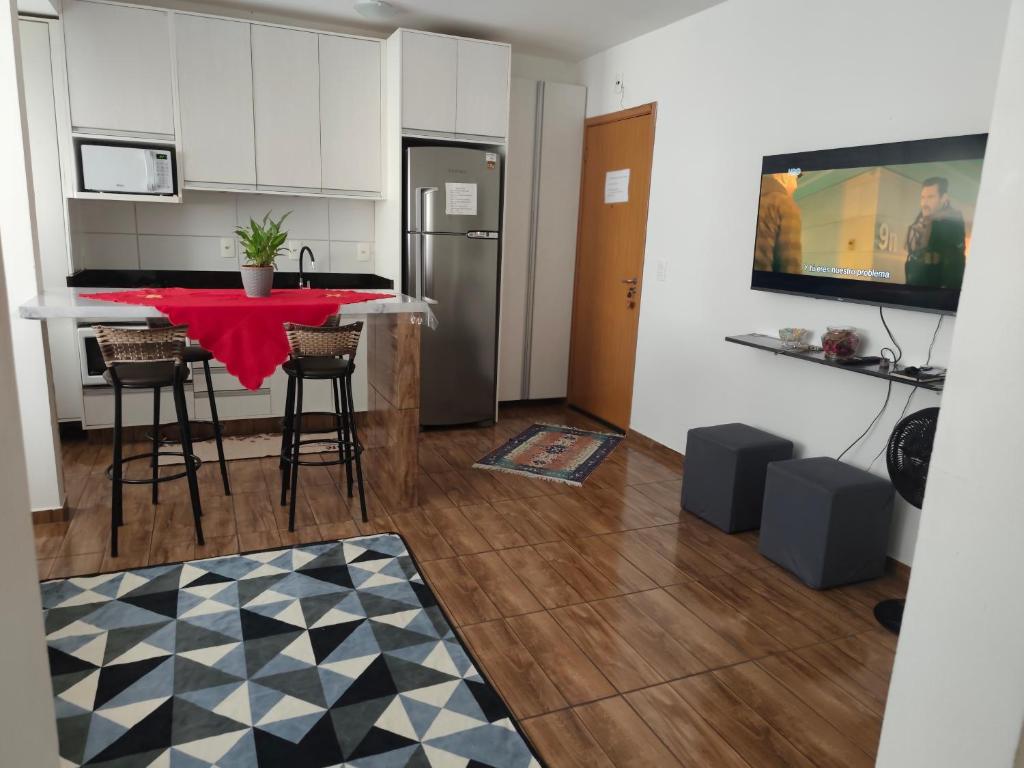 a kitchen with a red table in a room at Apt confortável in Camboriú