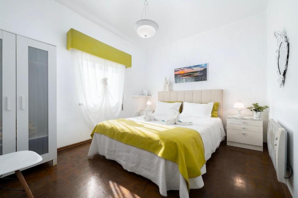 a bedroom with a bed with a yellow blanket at Casa Morais in Odeceixe