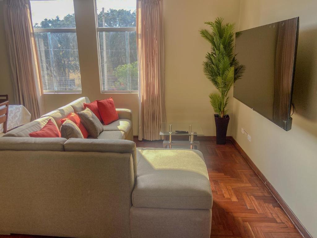 a living room with a couch and a potted plant at High Garden Apartment in Trujillo