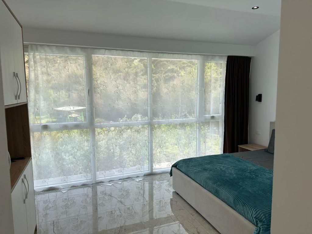 a bedroom with a bed and a large window at guest house Qyteza in Shkodër