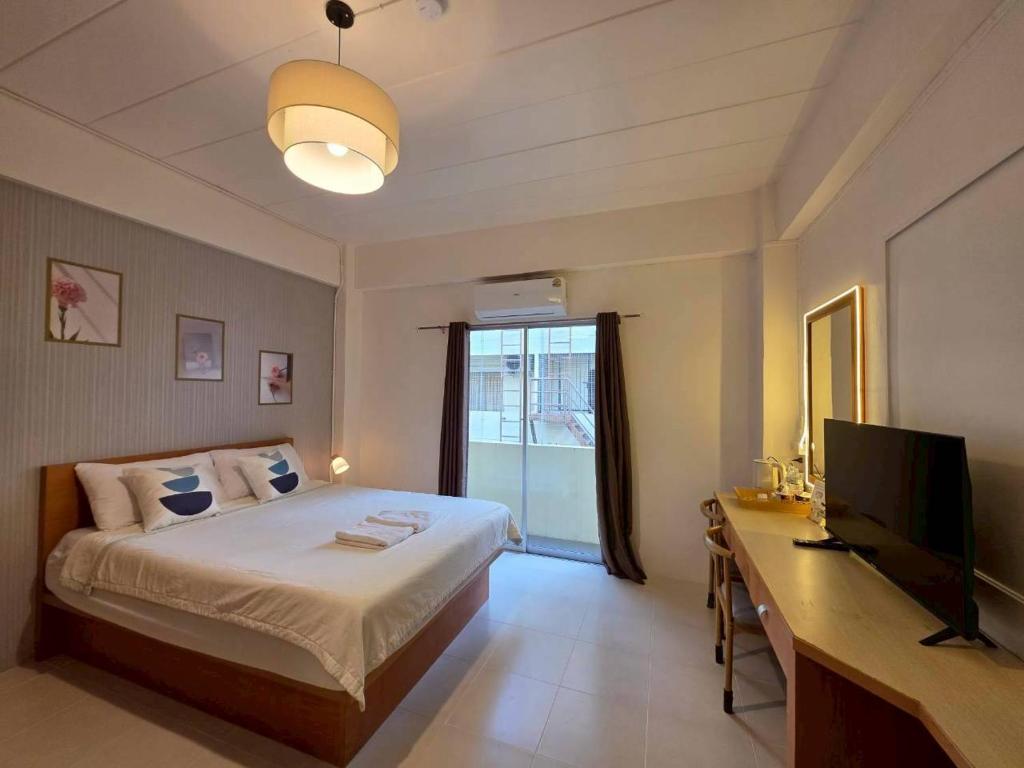 a bedroom with a bed and a desk and a television at the stay bangsaen in Ban Rong Khoei