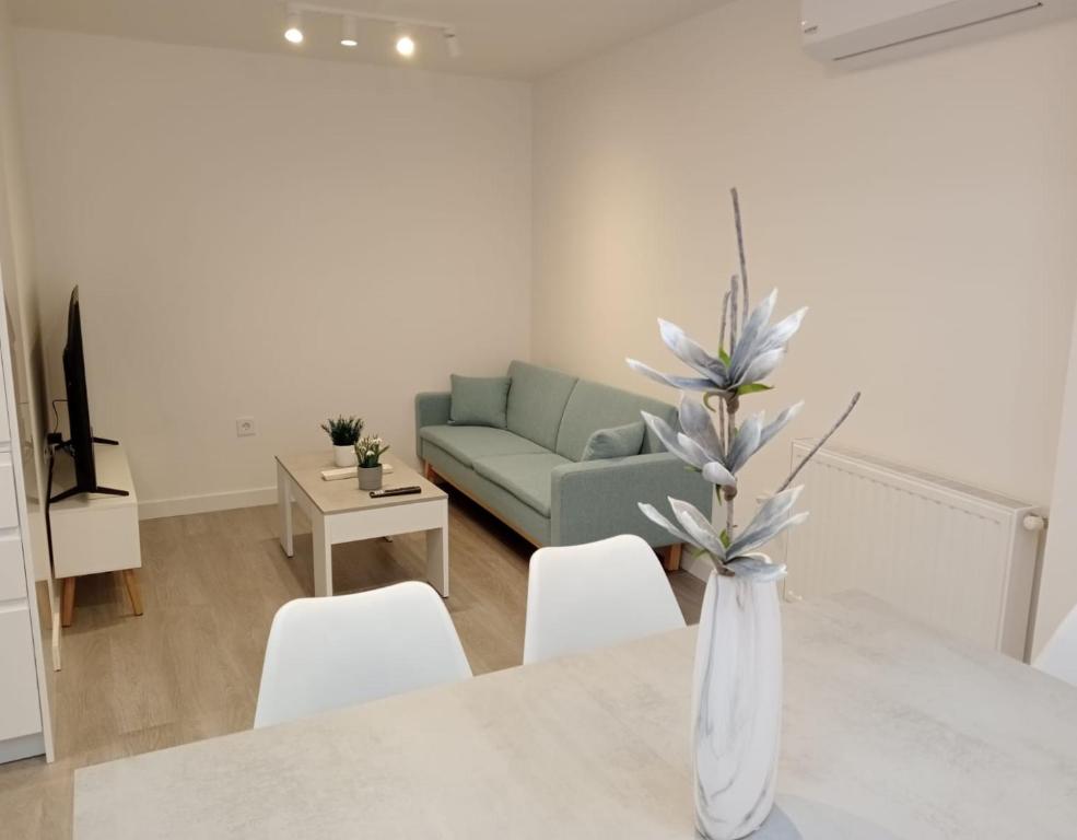 a living room with a couch and a table with white chairs at Apartamentos Antuña in Cangas de Onís