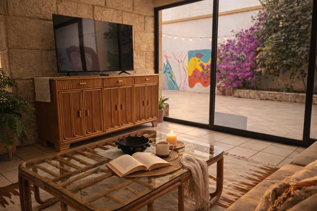 a living room with a coffee table and a tv at Casa Ritual tu refugio con jardín & 4 recámaras in Oaxaca City