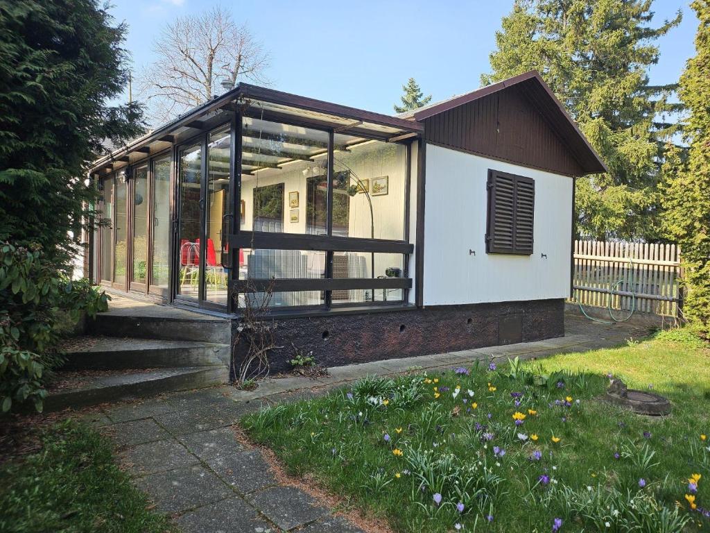 a house with glass windows and a garden at Ferienhaus-Maxen in Müglitztal