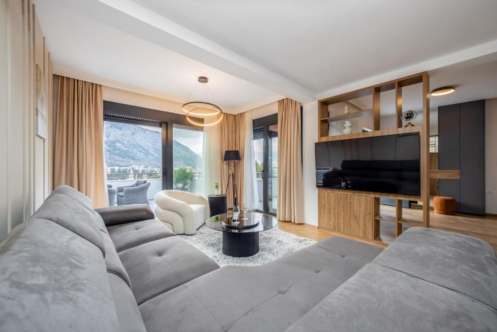 a living room with a couch and a television at Villa Azure Luxe in Škaljari