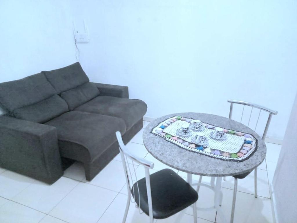 a living room with a couch and a table and chairs at Casa simples e aconchegante em Poços de caldas in Poços de Caldas