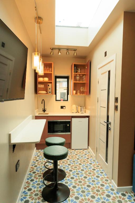 a kitchen with a counter and a stool and a counter top at Heathrow Royal Apartment in Ashford