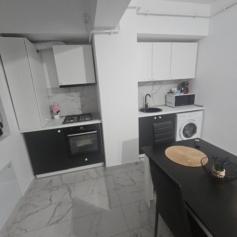 a kitchen with black and white appliances and a table at New studio in Râmnicu Vâlcea