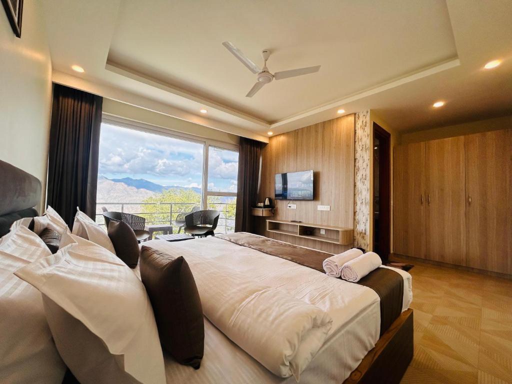 a bedroom with a large bed with a large window at The Hill Heaven A Luxury Property With Balcony & Mountain View Rooms in Mussoorie
