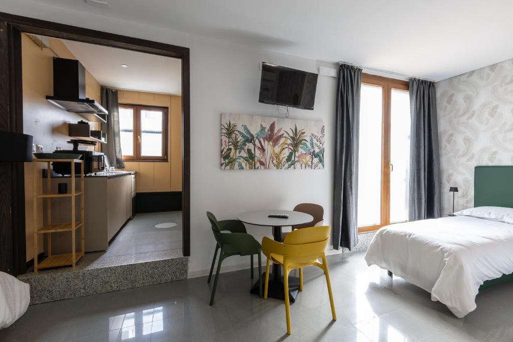 a bedroom with a bed and a table and chairs at Foresteria SMART ROOMS in Viadana
