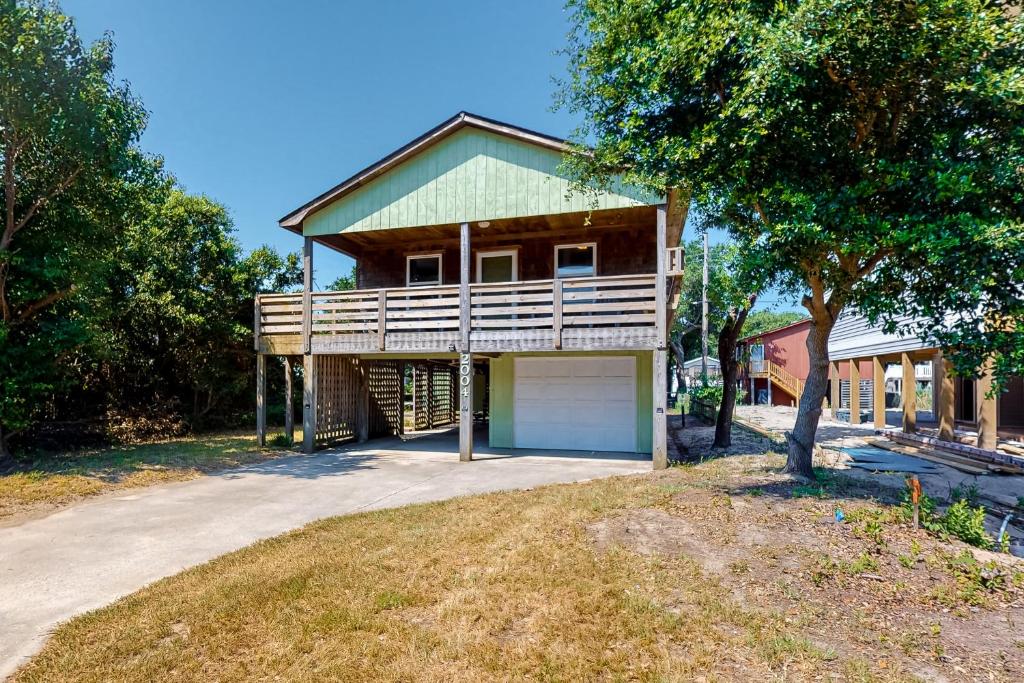 a house with a porch and a garage at The Flying Dutchman OBX in Kill Devil Hills