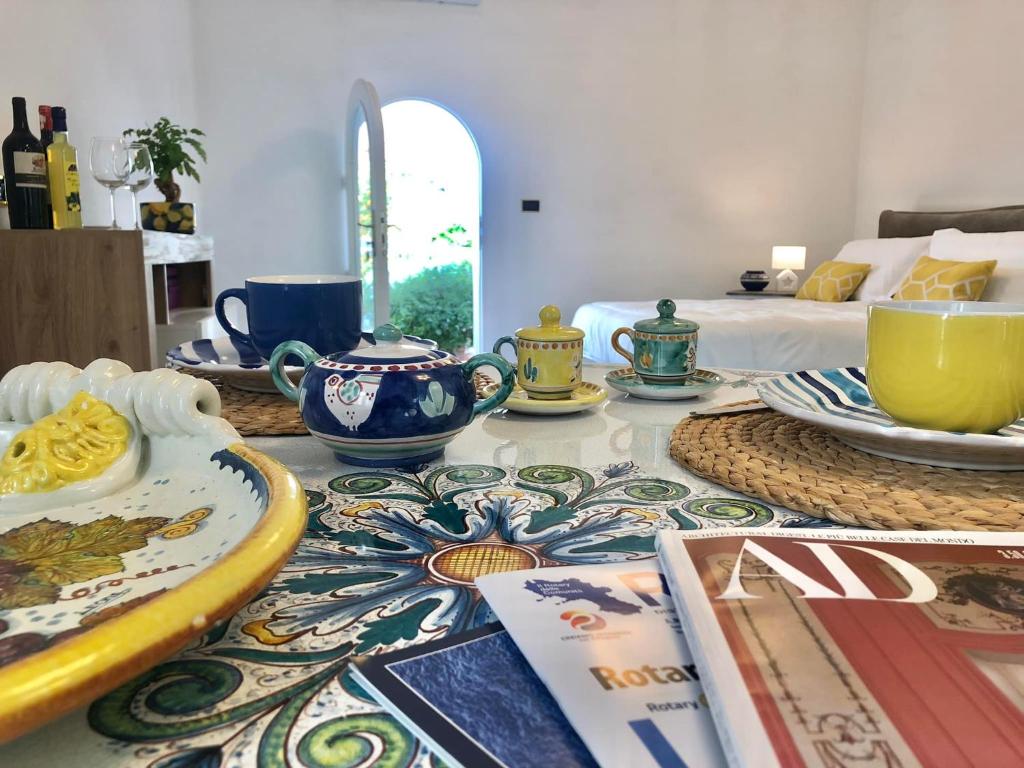 a table with plates and bowls on it with a bed at Syrene Suites Sorrento in Piano di Sorrento
