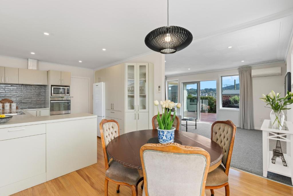 a kitchen and dining room with a table and chairs at Roslyn Sanctuary Highgate Dunedin in Dunedin