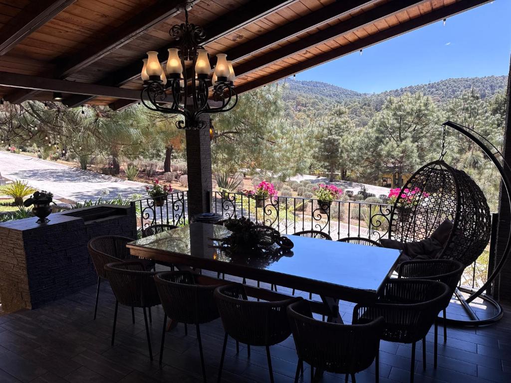 a dining table and chairs on a patio with a view at Cabañas Puerta del Bosque núm 2 in Mazamitla