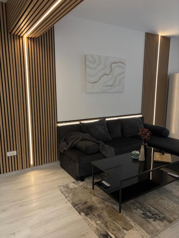 a living room with a black couch and a table at The Urban Hide by D'or Selection in Bucharest