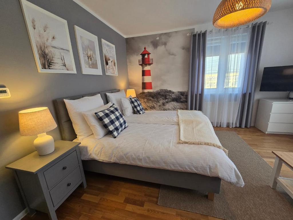 a bedroom with a bed with a red lighthouse on the wall at Apartamenty Aquarius - Latarnik in Gdynia