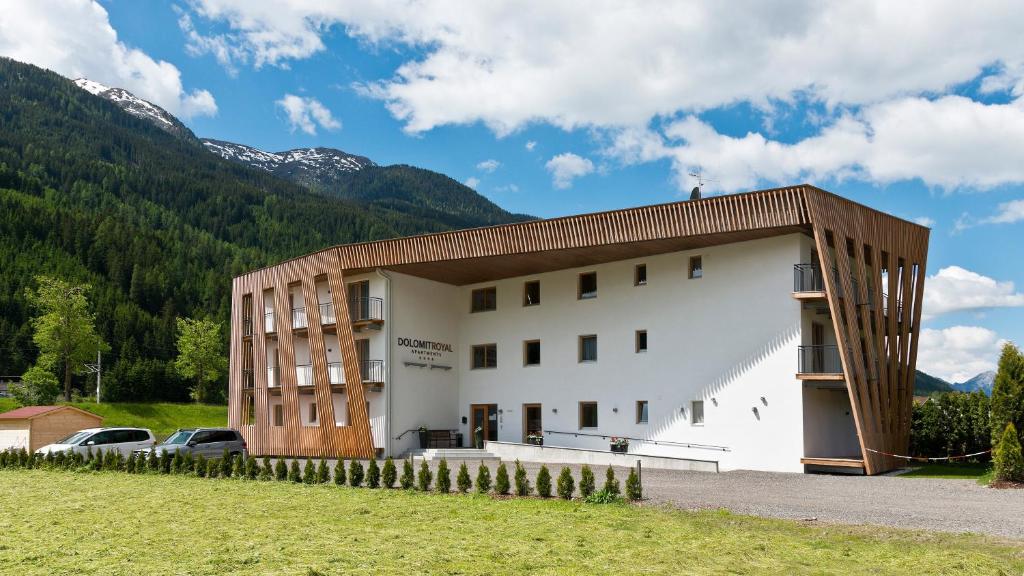a large white building with a brown roof at Apartments Dolomit-Royal in Sillian