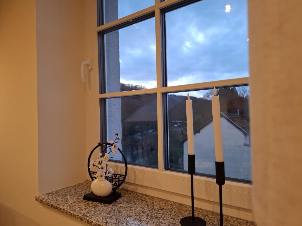 a window with three candles sitting on a counter at Ferienwohnung Elisabeth 2 Waxweiler in Waxweiler