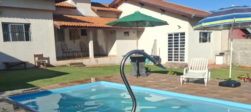 a person pouring a hose into a swimming pool at Chácara Florida Boituva in Boituva