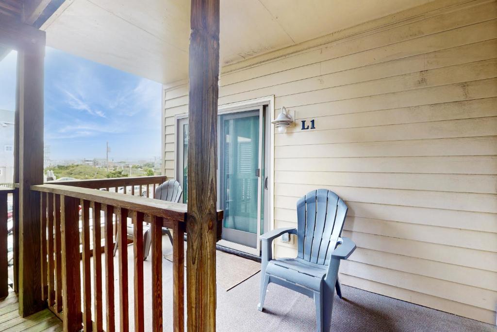 a blue chair sitting on the porch of a house at Virginia Dare Escape in Kill Devil Hills