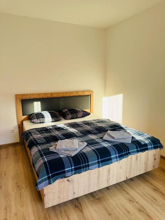 a bedroom with a bed with a blue plaid blanket at Apartament UNO in Reşiţa