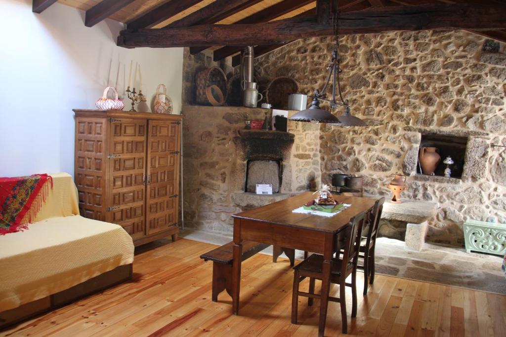 ein Wohnzimmer mit einem Tisch und einem Steinkamin in der Unterkunft Casa Maria da Assunção in Vila Nova de Cerveira