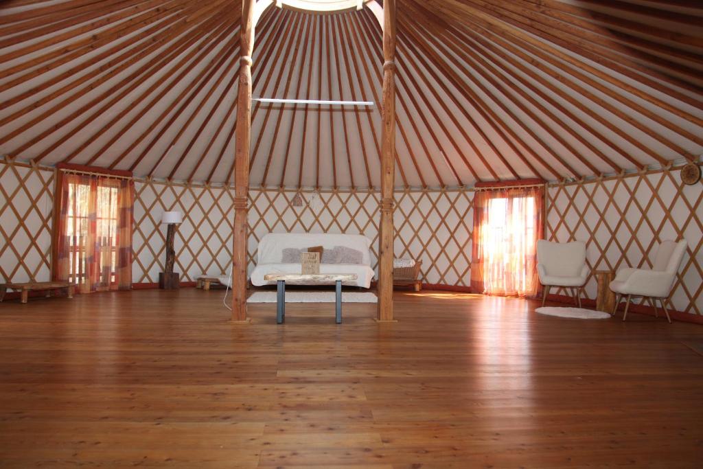 a large tent with a bed and chairs in it at Jurta Les Park in Vřesovice