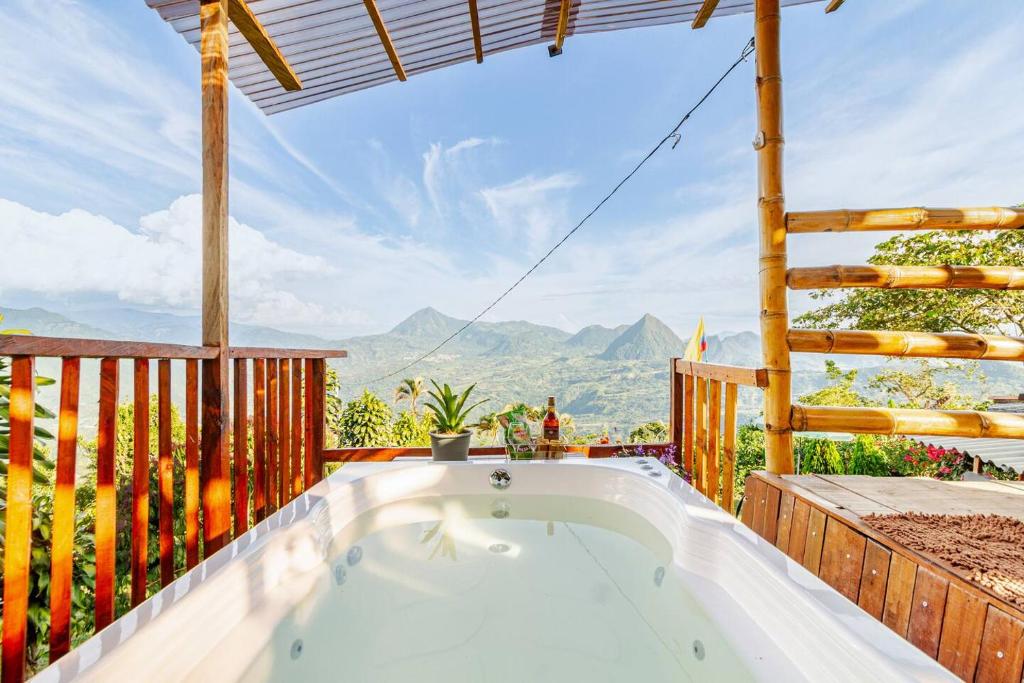 a hot tub on a deck with a view of the mountains at Titiribi-Antioquia- Cabaña el sol in Titiribí