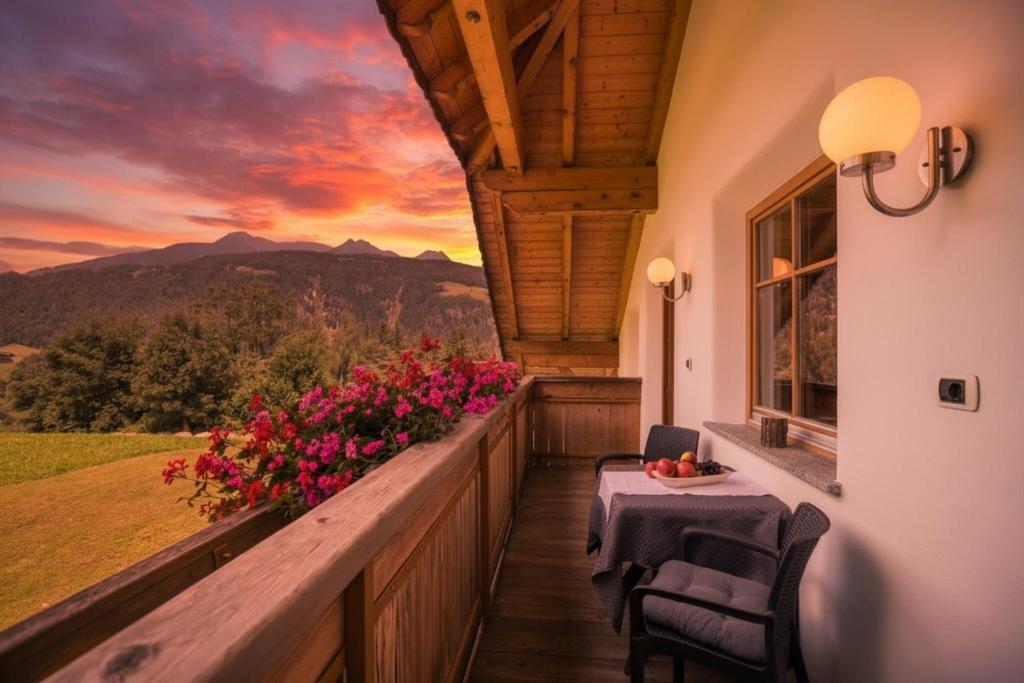 a balcony of a house with a table and flowers at Oberplunerhof - Fewo Gitschberg in Chienes
