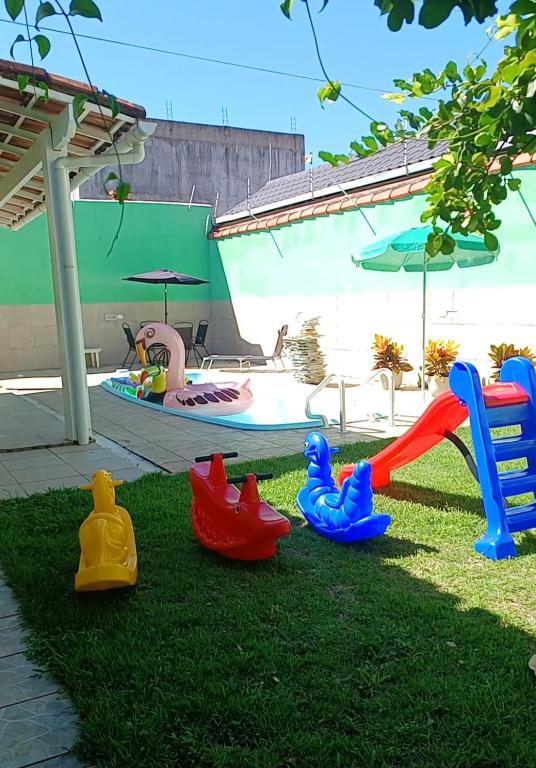 a group of plastic toys on the grass near a pool at Família Castro Ostras in Rio das Ostras