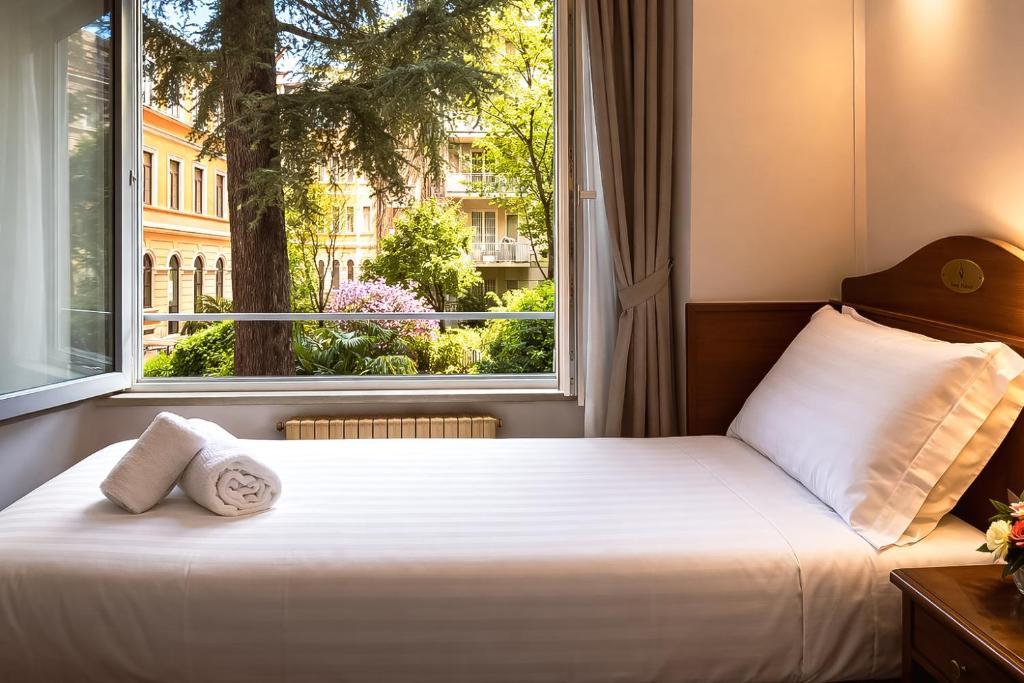 a bed in a room with a large window at Hotel Pavone in Milan
