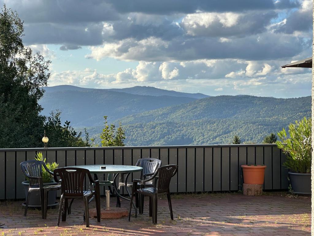 a table and chairs on a patio with a view of mountains at Moderne Apartments im Bayerischen Wald mit Bergblick, Balkon & großer Terrasse in Schöfweg
