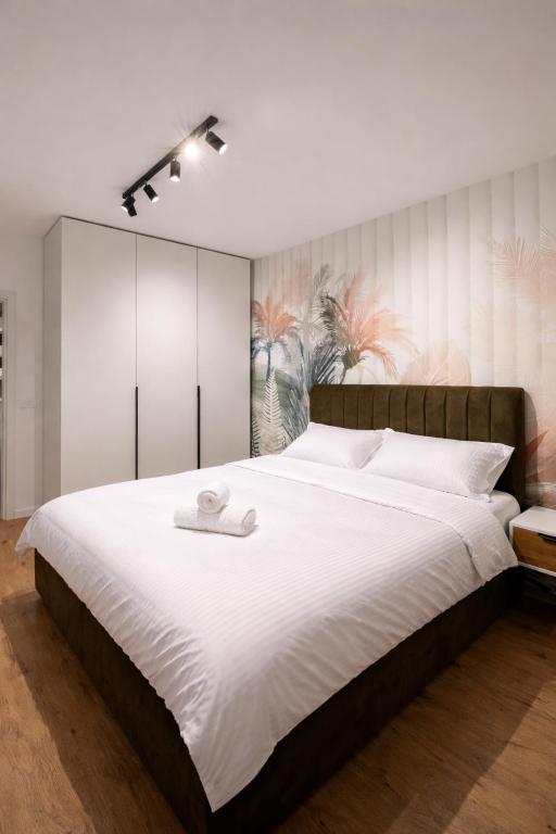 a bedroom with a large bed with white sheets at Apartament Modern Urban Space - FREE Parking in Voluntari