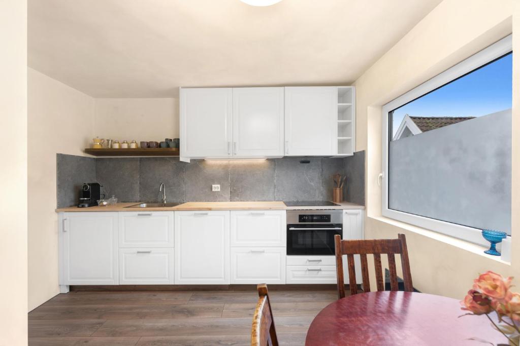 a kitchen with white cabinets and a table and a window at Central Apartment - Calm - No traffic in Stavanger