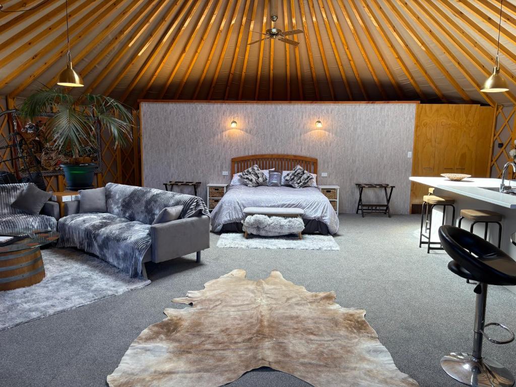 a bedroom with a bed and a couch and a table at Riverview Yurt in Tarras