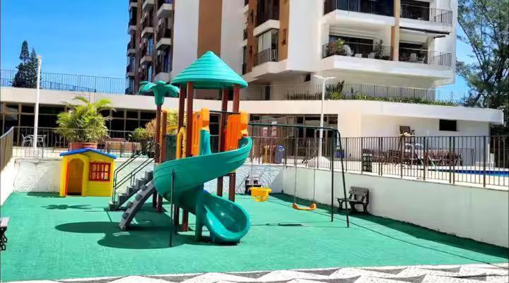 a playground in front of a building with a slide at Rio Hotel Reisdence in Água Boa